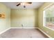 Neutral toned bedroom with a window and a ceiling fan with light, perfect for relaxation at 27930 Ravens Brook Rd, Wesley Chapel, FL 33544