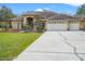 Home featuring a three-car garage and inviting entrance at 27930 Ravens Brook Rd, Wesley Chapel, FL 33544