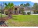 Charming home featuring a manicured lawn, palm trees and a three car garage at 27930 Ravens Brook Rd, Wesley Chapel, FL 33544