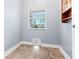 Functional laundry room with tile floors, base cabinets, a window, and a convenient pet door at 27930 Ravens Brook Rd, Wesley Chapel, FL 33544