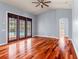 Living room featuring hardwood floors, a ceiling fan, and double doors that lead to a pool at 27930 Ravens Brook Rd, Wesley Chapel, FL 33544
