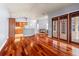 Living room featuring hardwood floors, a kitchen, a fireplace, and double doors that lead to the outdoors at 27930 Ravens Brook Rd, Wesley Chapel, FL 33544
