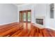 Spacious living room with hardwood floors, a stone fireplace, and sliding glass doors to the pool at 27930 Ravens Brook Rd, Wesley Chapel, FL 33544