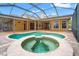 Inviting outdoor pool and spa area with a screened enclosure and a spacious deck at 27930 Ravens Brook Rd, Wesley Chapel, FL 33544