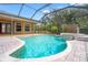 A screened-in pool area with a brick deck and a spa at 27930 Ravens Brook Rd, Wesley Chapel, FL 33544