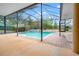 Lush outdoor pool area featuring a serene pool, screened enclosure, and well-maintained patio at 27930 Ravens Brook Rd, Wesley Chapel, FL 33544