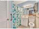 Bathroom with blue accents, featuring a shower/tub, toilet, and a vanity with cabinet storage at 3112 S Julia Cir, Tampa, FL 33629