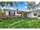 Charming single story home with brick accents, dark shutters, mature landscaping, and a cozy front porch seating area at 3112 S Julia Cir, Tampa, FL 33629