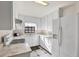 Compact kitchen featuring white cabinets, countertops, and appliances, creating a bright and efficient cooking space at 3112 S Julia Cir, Tampa, FL 33629