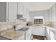 Bright kitchen featuring white cabinetry, stone counters, and modern appliances for a functional cooking space at 3112 S Julia Cir, Tampa, FL 33629