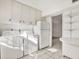 Bright laundry room with washer, dryer, refrigerator, tile floors, and storage shelves at 3112 S Julia Cir, Tampa, FL 33629