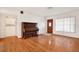 Spacious living room with hardwood floors, a piano, and ample natural light coming through the front door window at 3112 S Julia Cir, Tampa, FL 33629