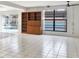 Open-concept living room featuring tile flooring, a bookcase, and views of the private outdoor pool area at 3112 S Julia Cir, Tampa, FL 33629