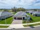 An aerial view of a house with a well-maintained lawn and a paver driveway and surrounded by lush trees at 31999 Surfton Knot Ct, San Antonio, FL 33576