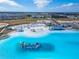 Stunning aerial view of a lagoon featuring white sand beaches and inflatable water park in a residential community at 31999 Surfton Knot Ct, San Antonio, FL 33576