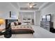 Bright bedroom with tray ceilings, large windows, and tasteful decor with mounted television at 31999 Surfton Knot Ct, San Antonio, FL 33576