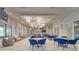 Elegant clubhouse featuring tables with blue chairs, chandeliers, and cozy wicker seating areas at 31999 Surfton Knot Ct, San Antonio, FL 33576