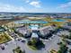 Aerial view of a community clubhouse, pools, and recreational areas near a scenic lake at 31999 Surfton Knot Ct, San Antonio, FL 33576