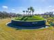 Impressive community entrance featuring lush landscaping, palm trees, and welcoming signage at 31999 Surfton Knot Ct, San Antonio, FL 33576