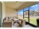 Relaxing screened-in lanai with comfortable seating area and ceiling fan overlooking lush green backyard at 31999 Surfton Knot Ct, San Antonio, FL 33576