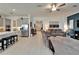 Spacious living room featuring tile floors, ceiling fan and view into the kitchen with stainless steel appliances at 31999 Surfton Knot Ct, San Antonio, FL 33576