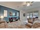 Comfortable living room boasts a statement wall, ceiling fan, and access to the screened lanai at 31999 Surfton Knot Ct, San Antonio, FL 33576