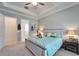 Bright main bedroom featuring tray ceiling, ceiling fan, and coastal decor at 31999 Surfton Knot Ct, San Antonio, FL 33576