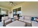 Relaxing covered patio with comfortable seating and a ceiling fan, perfect for outdoor lounging at 31999 Surfton Knot Ct, San Antonio, FL 33576