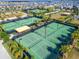 Aerial view of multiple tennis courts with shade structures, perfect for community tournaments at 31999 Surfton Knot Ct, San Antonio, FL 33576