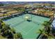 Aerial view of immaculately maintained tennis courts and covered seating in a vibrant community at 31999 Surfton Knot Ct, San Antonio, FL 33576
