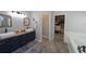 Bathroom featuring double sinks, wood counters, blue cabinets, and a walk-in closet at 3233 Russett Pl, Land O Lakes, FL 34638