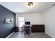 Home office with desk, dark accent wall, light wood floors, and ample natural light at 3233 Russett Pl, Land O Lakes, FL 34638
