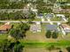 Aerial shot of home with a well-maintained lawn and neighborhood with mature trees at 3515 Nemo Ave, North Port, FL 34287