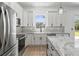 Well-lit modern kitchen featuring an island, stainless steel appliances, and sleek backsplash at 3515 Nemo Ave, North Port, FL 34287