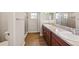 Bathroom featuring a double sink vanity, wood cabinets, large mirror, and a tiled walk-in shower at 35478 Bellington Blvd, Zephyrhills, FL 33541