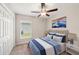 Comfortable bedroom with a ceiling fan, natural light, and complemented by soft, plush carpeting at 35478 Bellington Blvd, Zephyrhills, FL 33541