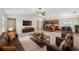 Open-concept living room with a ceiling fan, leading into a kitchen with wooden cabinets and a dining area at 35478 Bellington Blvd, Zephyrhills, FL 33541