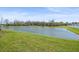 Scenic pond view with a backdrop of lush greenery, offering a tranquil outdoor ambiance at 35478 Bellington Blvd, Zephyrhills, FL 33541