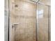 Tiled walk-in shower featuring glass door, shower head and decorative design at 35478 Bellington Blvd, Zephyrhills, FL 33541