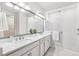 Luxurious bathroom with dual sinks, quartz countertops, and a glass-enclosed shower at 3579 Sweet Mabolo St, Wesley Chapel, FL 33543