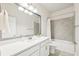 Well-lit bathroom with a large mirror, single sink, and a bathtub at 3579 Sweet Mabolo St, Wesley Chapel, FL 33543