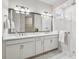 Modern bathroom with double vanity, sleek mirrors, tiled shower, and elegant fixtures at 3579 Sweet Mabolo St, Wesley Chapel, FL 33543