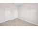 Empty room with light wood-look flooring and two doors at 3579 Sweet Mabolo St, Wesley Chapel, FL 33543
