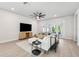 Open-concept living room with modern decor, large windows, and a comfortable seating area at 3579 Sweet Mabolo St, Wesley Chapel, FL 33543