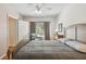 Comfortable bedroom with a ceiling fan, gray duvet, and a chair near the window at 3638 Trafalgar Way # 103, Palm Harbor, FL 34685