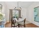 Bright dining space with a wooden table, seating for six, modern chandelier, and a view of the outdoors at 3638 Trafalgar Way # 103, Palm Harbor, FL 34685