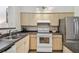 Bright kitchen featuring stainless steel refrigerator, oven, and ample cabinet space at 3638 Trafalgar Way # 103, Palm Harbor, FL 34685