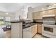 Cozy kitchen area with stainless steel sink, white appliances, and a view of the living space at 3638 Trafalgar Way # 103, Palm Harbor, FL 34685