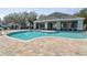 Large community pool with a modern design, surrounded by a paved deck and lounge chairs at 3638 Trafalgar Way # 103, Palm Harbor, FL 34685