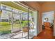 Screened-in porch with a view of the backyard and a glimpse into the house at 3638 Trafalgar Way # 103, Palm Harbor, FL 34685